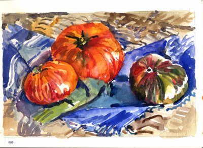 Still life with tomatoes or squash on a blue cloth over a patterned tabletop.
