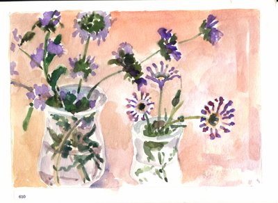 Two vases with purple flowers against a warm peach background.