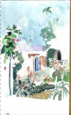 White building or courtyard wall with tropical plants and flowers.